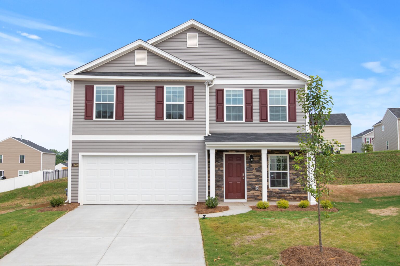 A house with a garage and driveway in front of it.