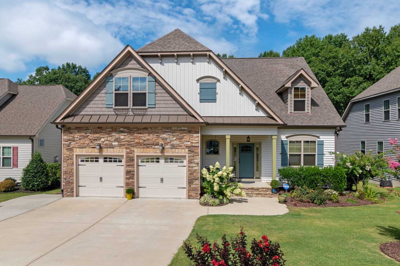 A large house with two garage doors and a driveway.